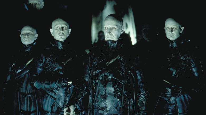 A group of Strangers standing together in "Dark City"
