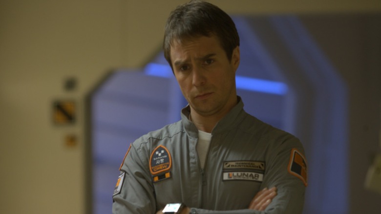 Sam standing with his arms crossed in "Moon"