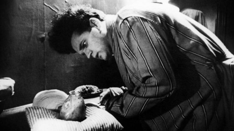 Henry leaning over alien baby