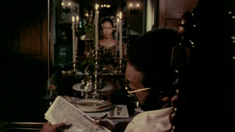 Ganja looking at Hess across candlelit table