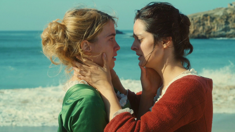 Héloïse and Marianne touch each other's faces on the beach in "Portrait of a Lady on Fire" (2019)