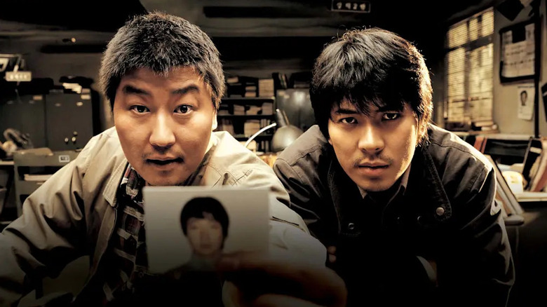 Detectives Park and Seo display a photo in "Memories of Murder" (2003)