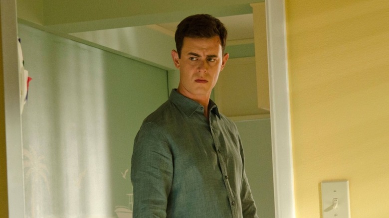 Travis appears to sneer while framed in a doorway on Dexter