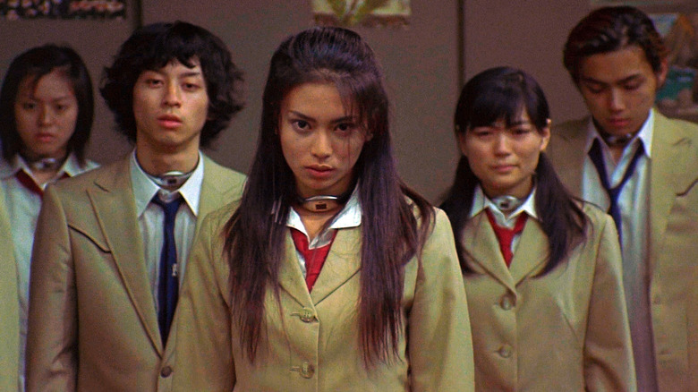 Teens in school uniforms wearing collars around their necks in 
