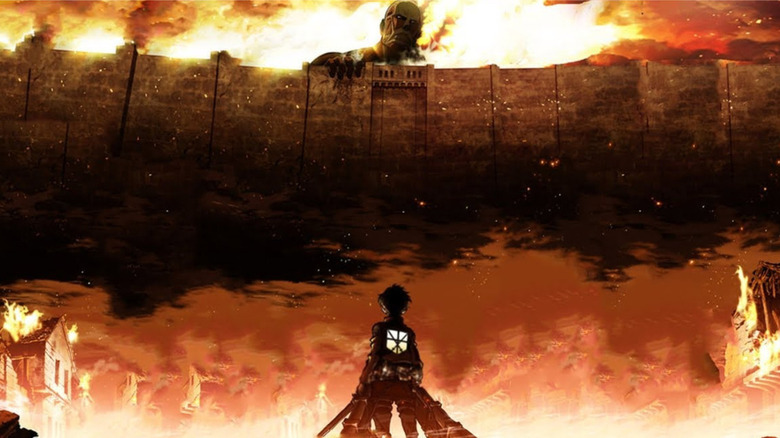 Eren Yeager staring at a Titan over the top of a flaming wall in the intro to Attack on Titan (2013)