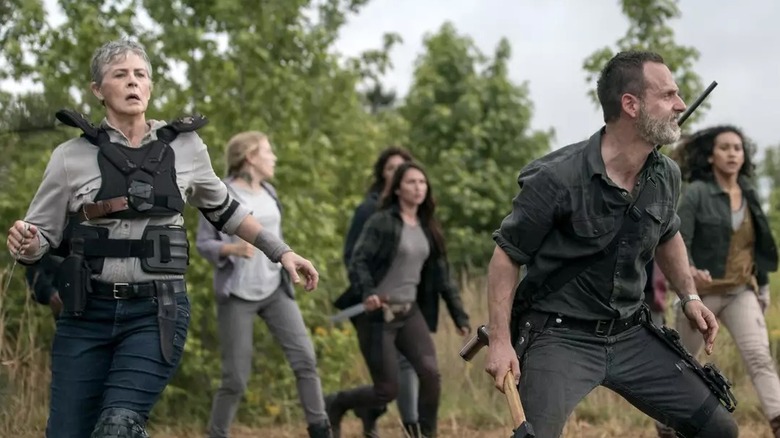 Carol, Rick, and others defending themselves against Walkers