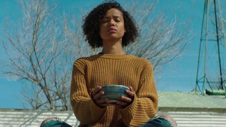 Ruth sitting on the roof holding a bowl with eyes closed in Fast Color (2019)