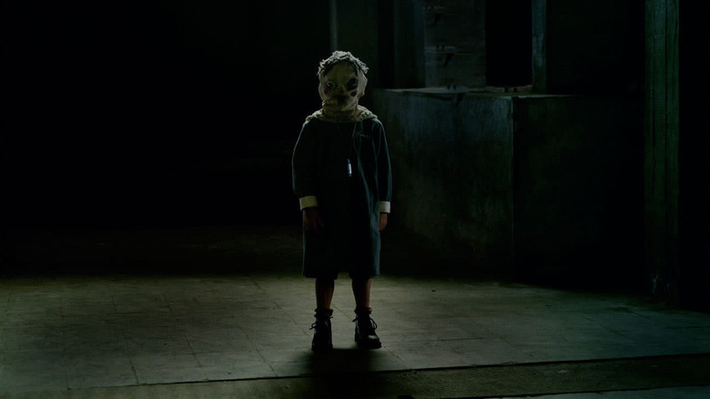 A masked child stands ominously in "The Orphanage" (2007)