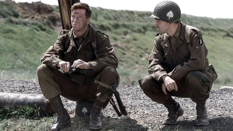 Dick and Lewis crouching and having a discussion in Band of Brothers