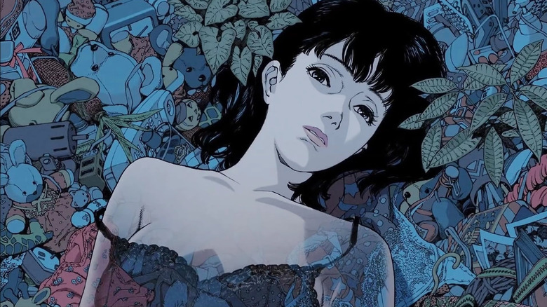 Mima lying in a pile of objects from her life