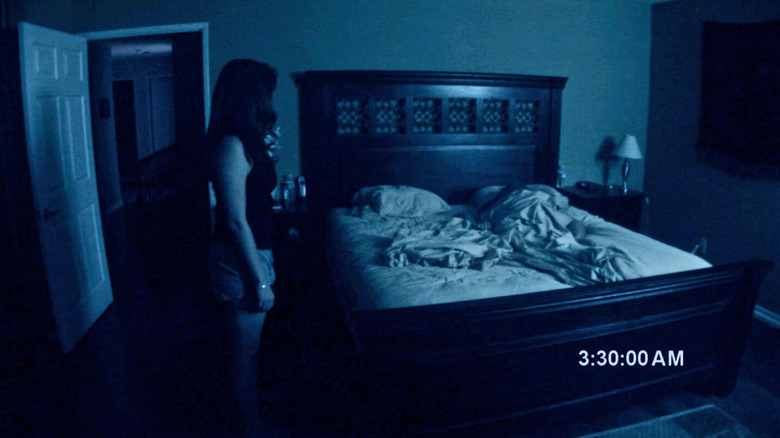 Katie standing by the bed
