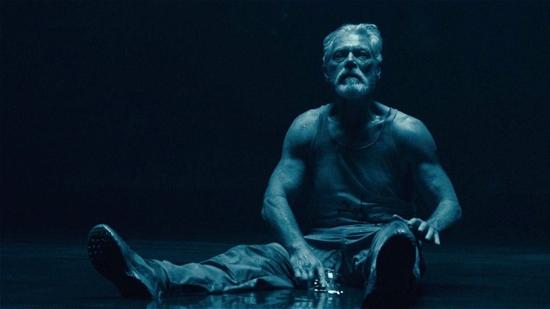 Norman Nordstrom sitting down in the dark in "Don't Breathe 2"