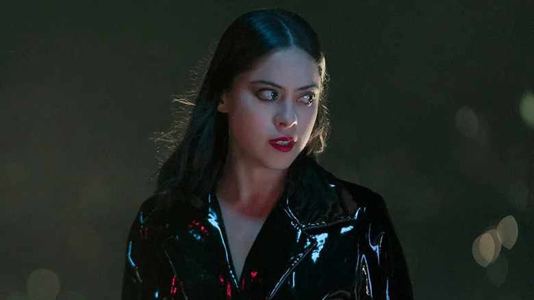 Lisa standing in a shimmering black coat at night in "Brand New Cherry Flavor" (2021)