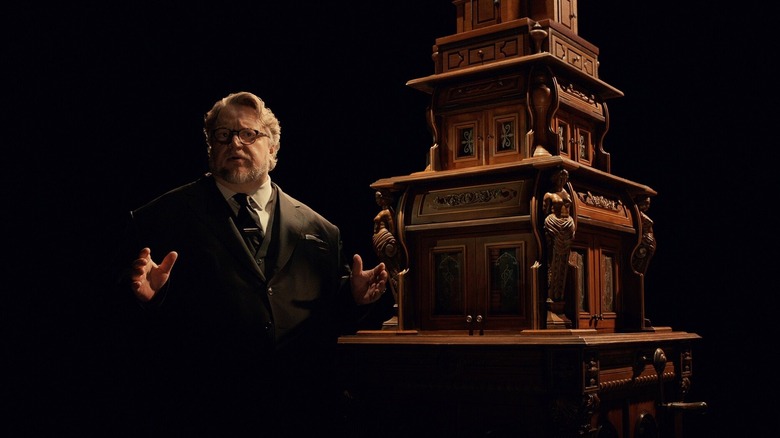 Guillermo del Toro standing with a cabinet in "Guillermo Del Toro's Cabinet of Curiosities" (2022)