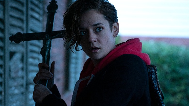 Emma holding a cross defensively in "Marianne" (2019)