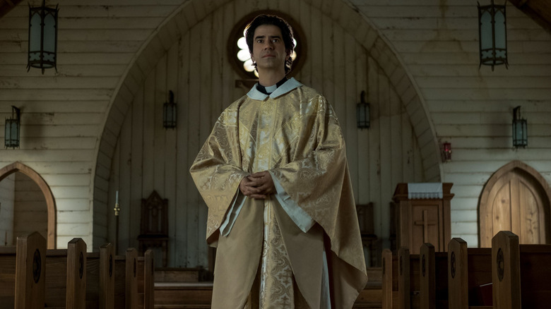 Father Paul standing in his church in "Midnight Mass" (2021)