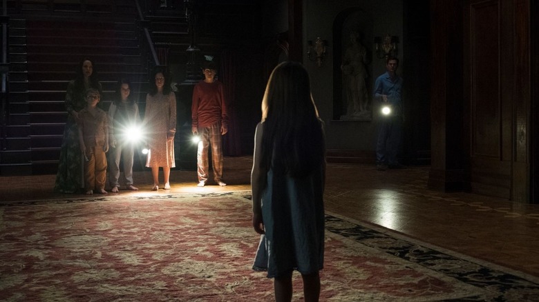 The Crain family standing in Hill House's foyer in "The Haunting of Hill House" (2018)
