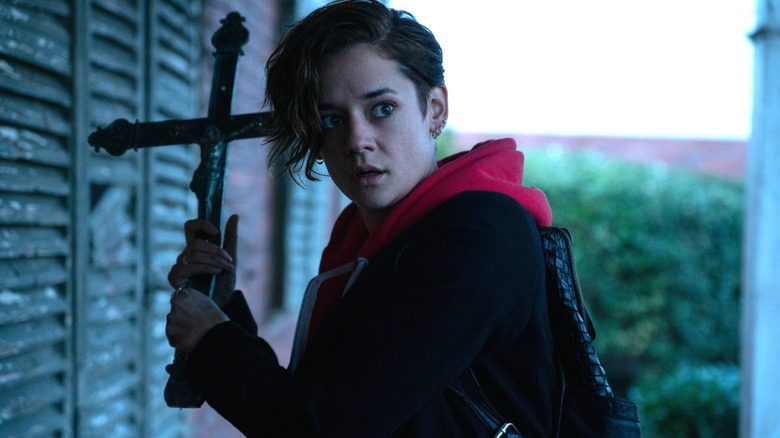 Emma holding a large cross in "Marianne."