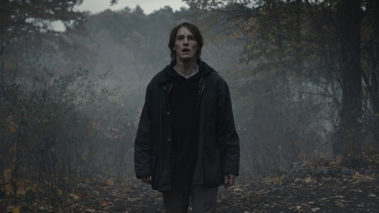 Jonas standing in the woods with a stunned expression on Dark