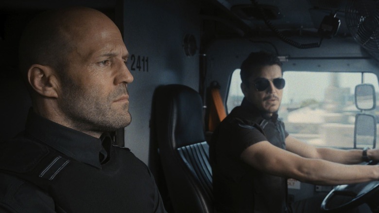 H sits in the passenger seat of an armored car in "Wrath of Man" (2021)