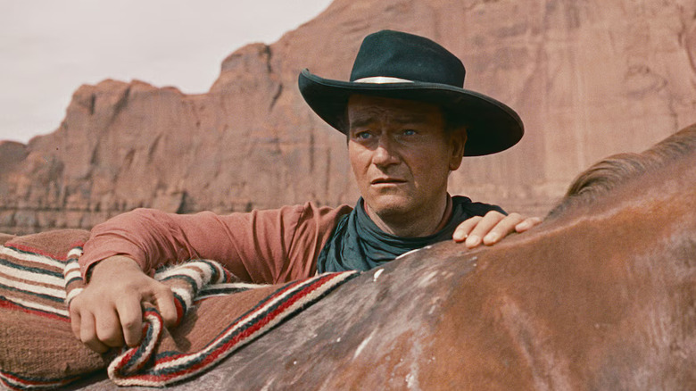 Ethan Edwards standing with a horse in "The Searchers" (1956)