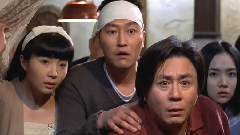 People looking at the body they just dug up in The Quiet Family (1998)