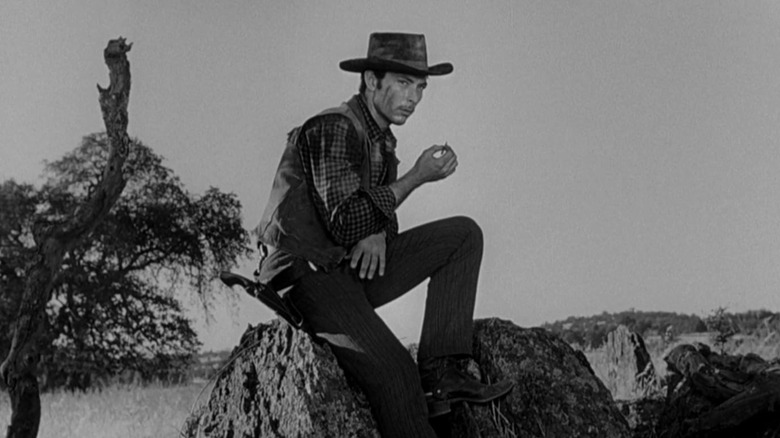 Jack Colby sitting on a rock in "High Noon"