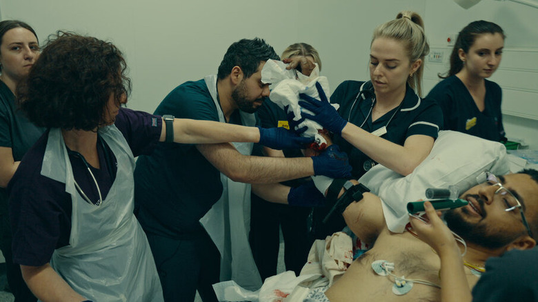 Physicians gather around to help a patient in "Critical: Between Life and Death"