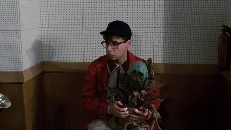Rick Moranis holds Audrey II in Little Shop of Horrors