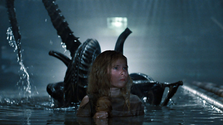 Newt in the water with a xenomorph behind her in Aliens