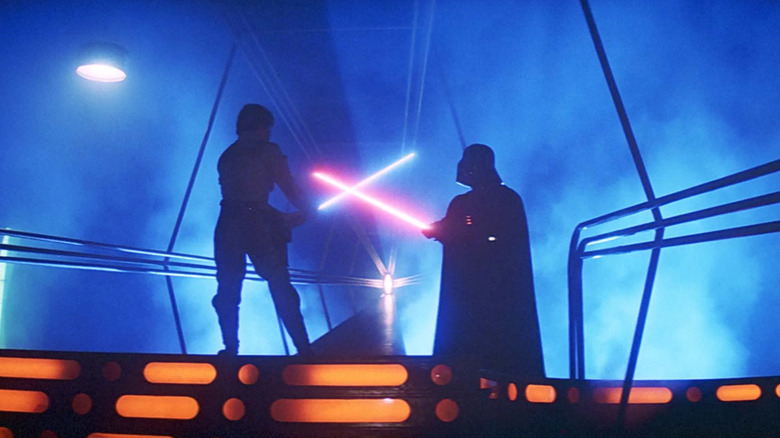 Luke Skywalker holds a blue lightsaber in a duel against Darth Vader and his red lightsaber in "The Empire Strikes Back"