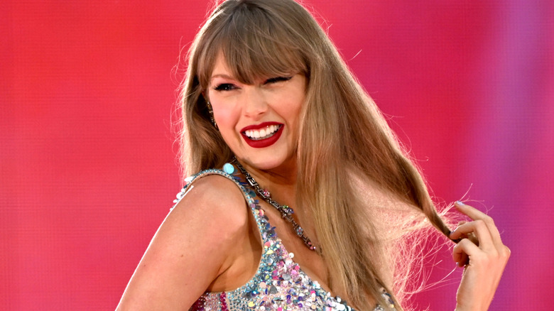 Taylor Swift playing with her hair and smiling during the Lover set in the Eras tour