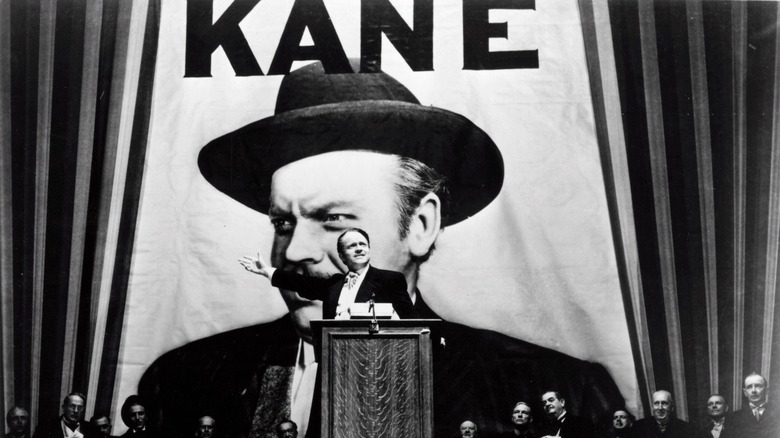 Charles Foster Kane standing behind a podium giving a speech in Citizen Kane (1941)