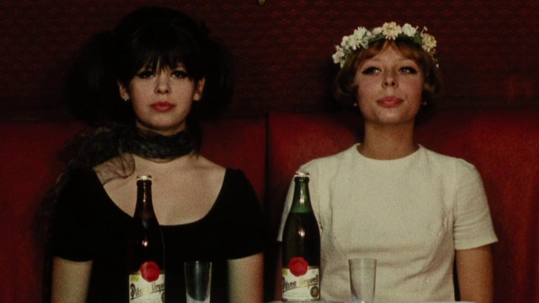 Marie I and Marie II sitting in a booth with some wine in Daisies (1966)