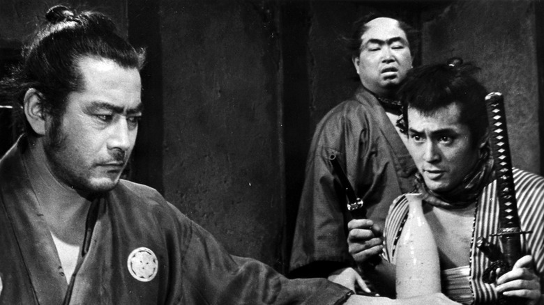 Kuwabatake Sanjuro listening to a deal in Yojimbo (1961)