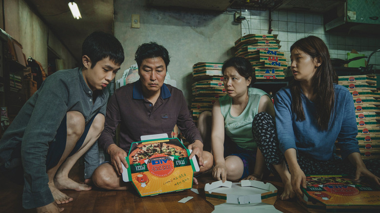 The Kim family inspecting a pizza box in Parasite (2019)