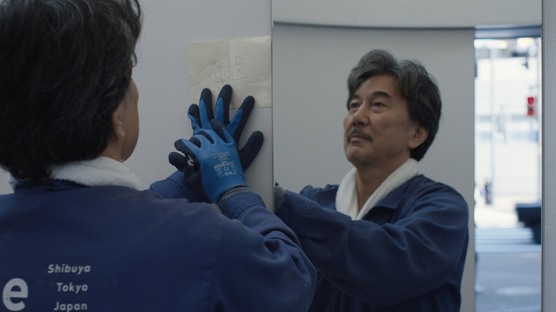 Hirayama washing down a mirror in Perfect Days (2023)