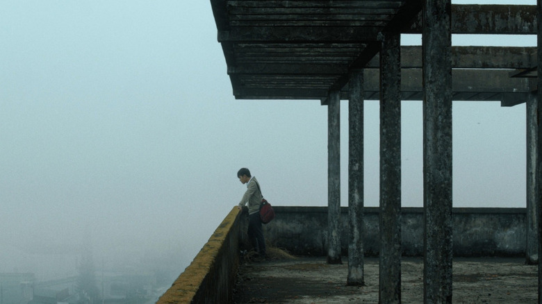 Thien looking over a foggy horizon in Inside the Yellow Cocoon Shell (2024)