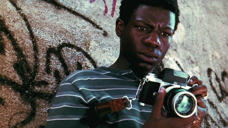 Rocket examining his photographs in City of God (2002)