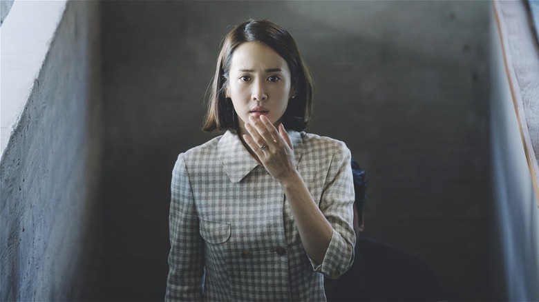 Choi Yeon-gyo looking scared on the stairs in Parasite