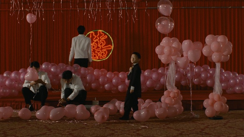 Yang-Yang standing around in a party in Yi Yi (2000)