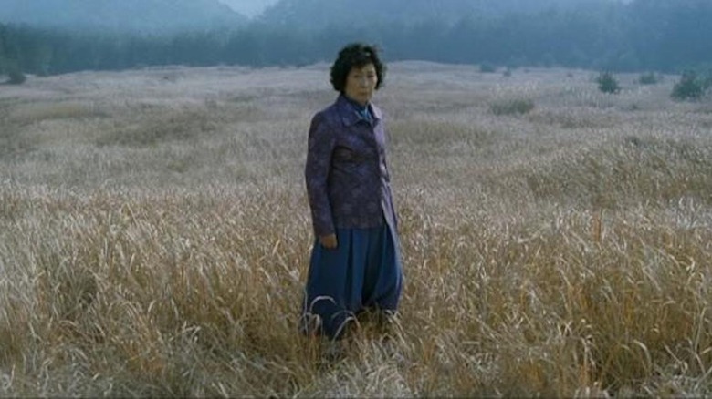Mother stands alone in field