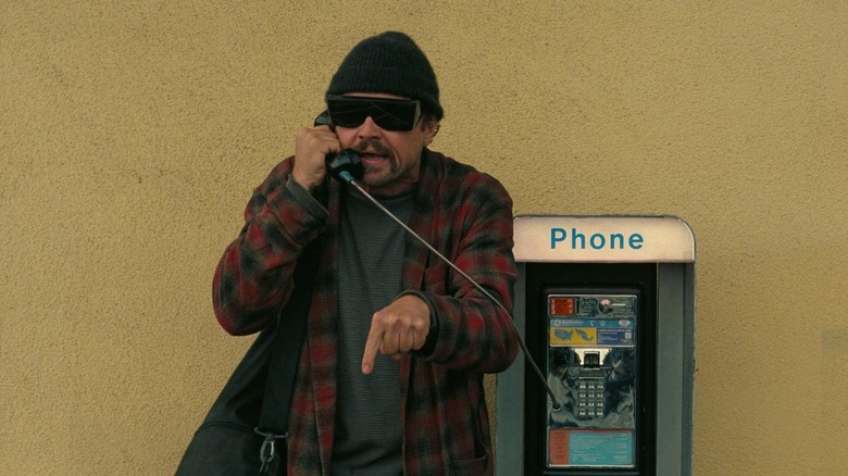 Bob Ferguson outside using payphone in "One Battle After Another"