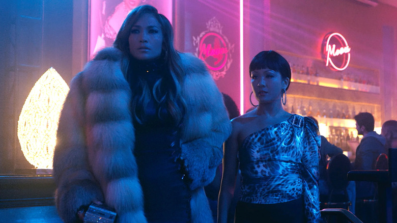 Ramona in a fur coat next to Dorothy in the club in Hustlers