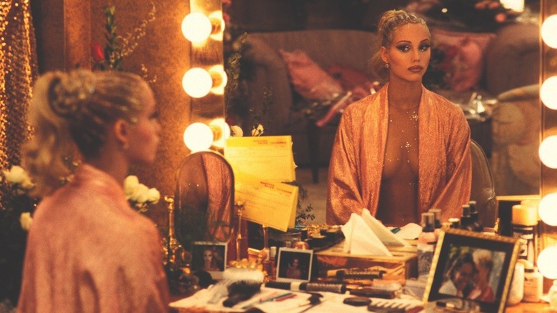 Nomi dressed up looking in the mirror in Showgirls