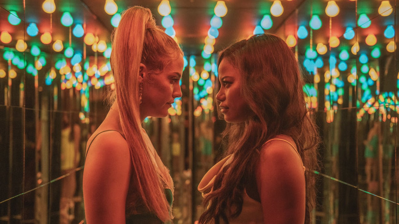 Zola and Stefani looking at each other with lights behind them in Zola