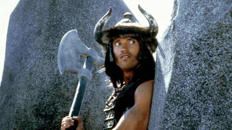 Conan hides behind rocks with an ax