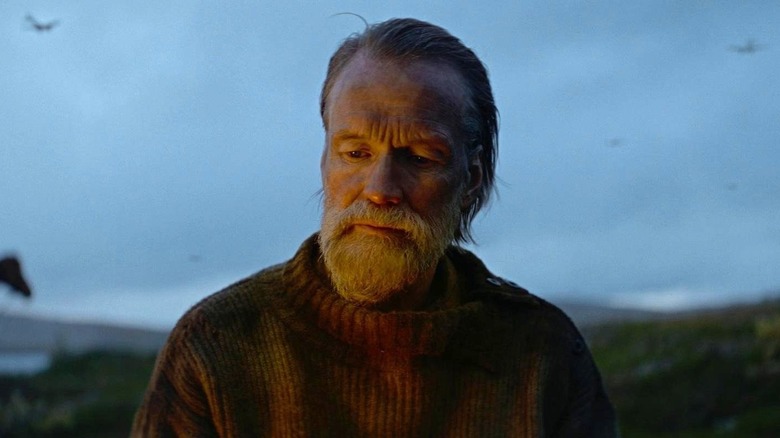 Aatami Korpi sitting by the fire in Sisu