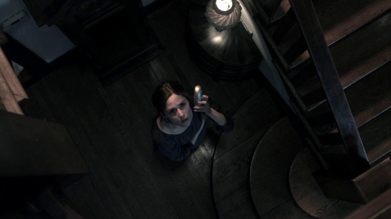 Renai Lambert standing by the staircase and looking up in Insidious