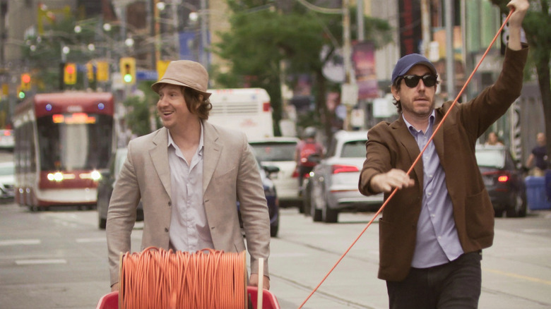 Matt and Jay walking down the street with a massive extension cord in